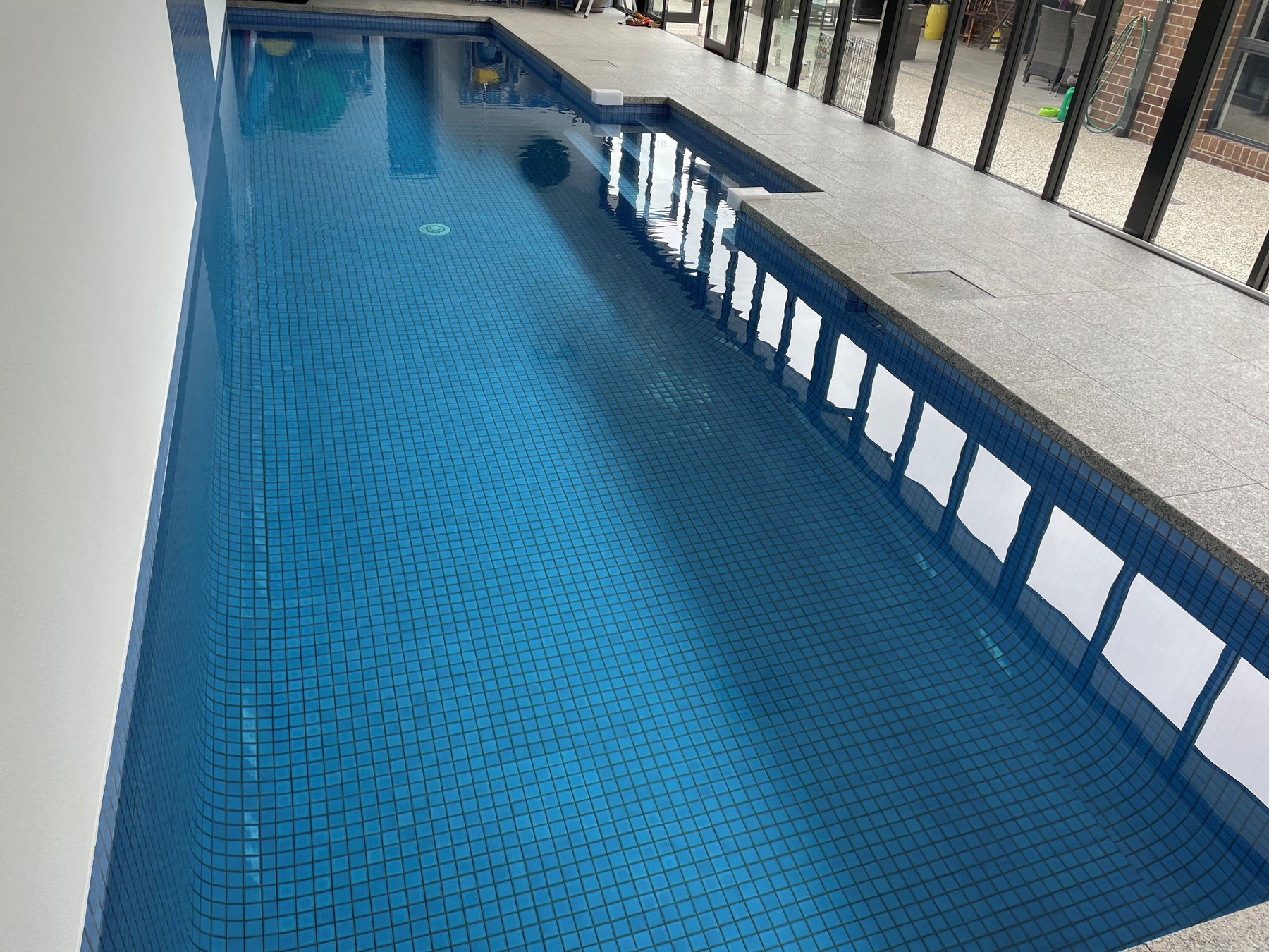 Concrete lap pool running the length of a narrow Melbourne garden